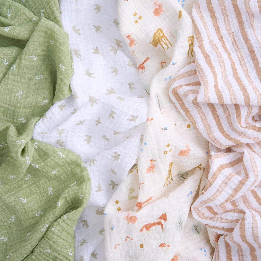 aden + anais essentials muslin swaddle Sage Woodland in action for swaddling, burping, or nursing cover.