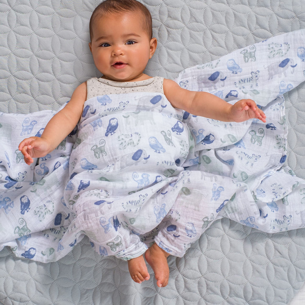 aden + anais Essentials swaddle blanket on baby demonstrates gentle drape for swaddling.