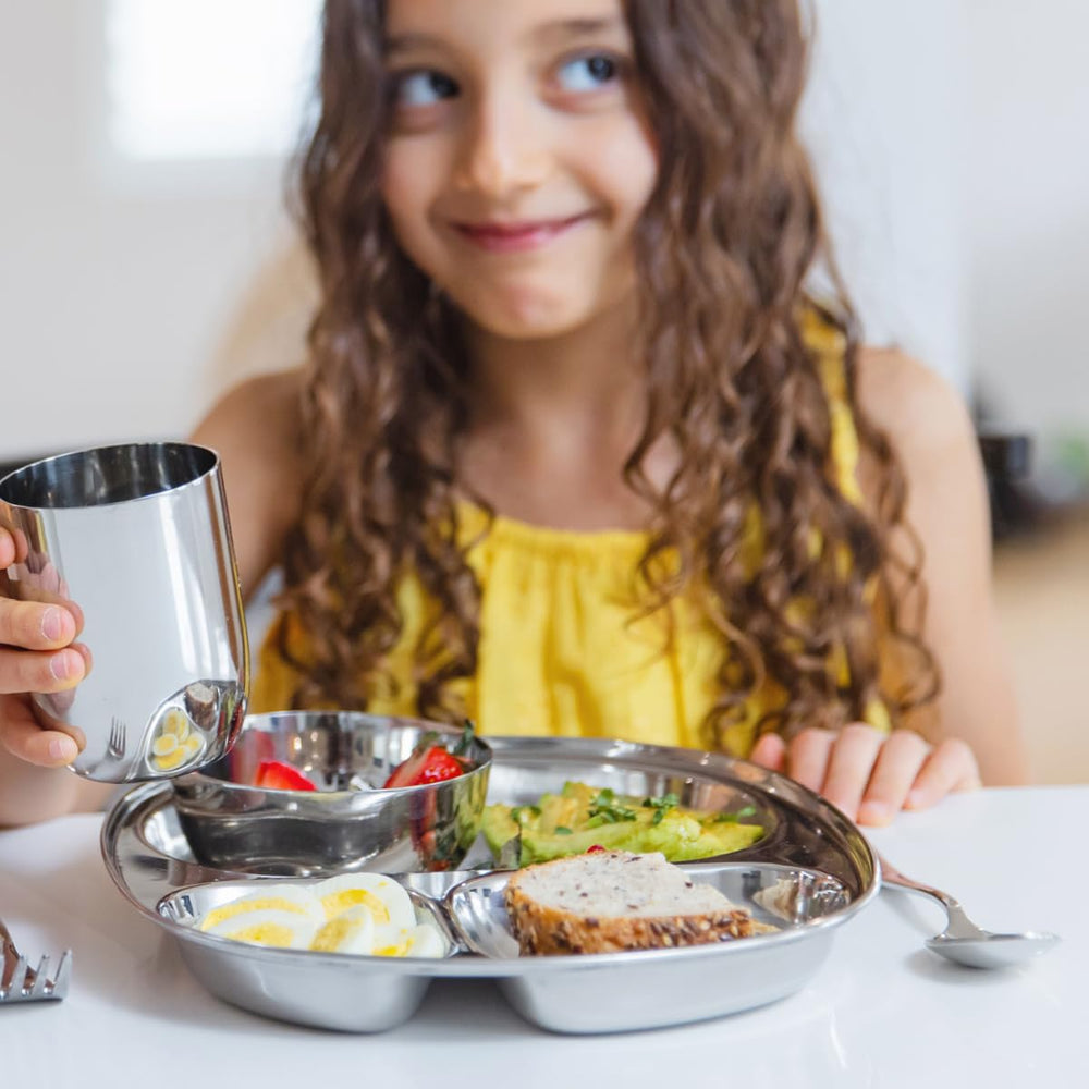 Ahimsa plate on table with family dinner emphasizes toxin-free, non-plastic dinnerware.
