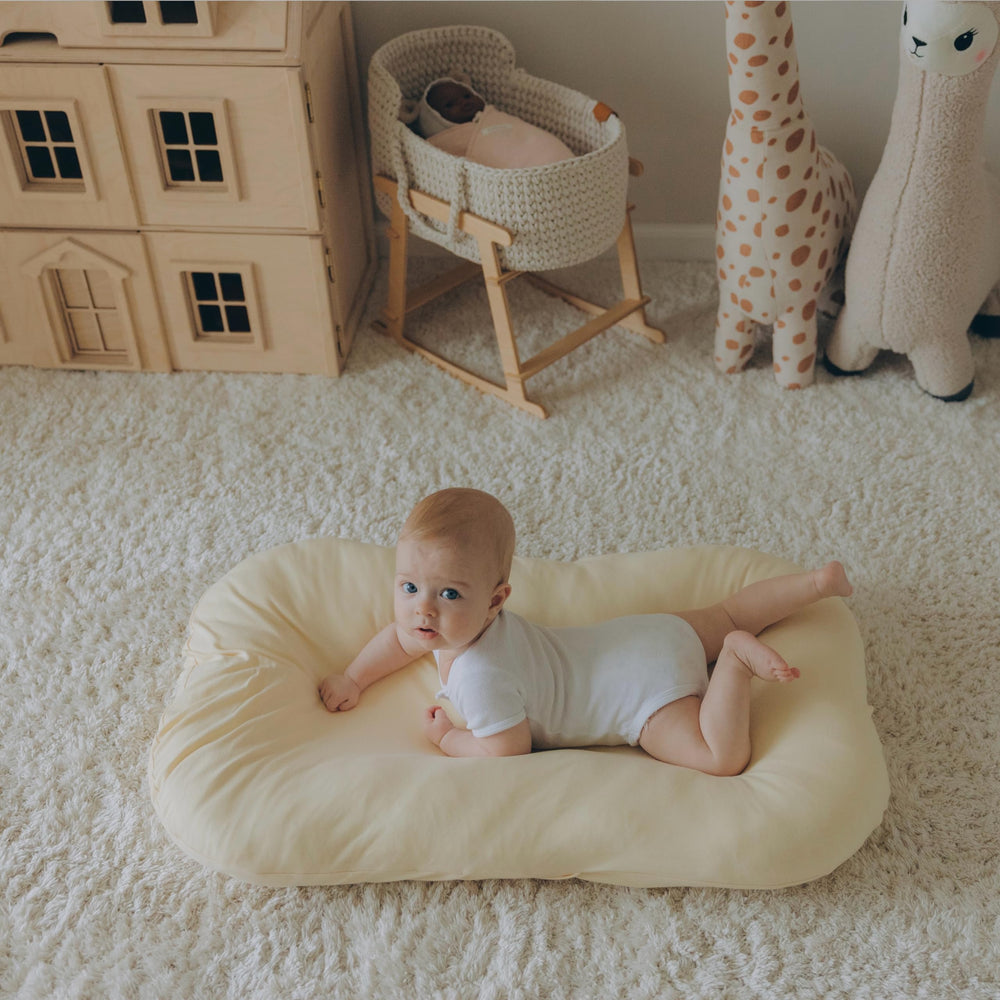 Aila + Aiden baby lounger cream fabric closeup highlights breathable organic cotton