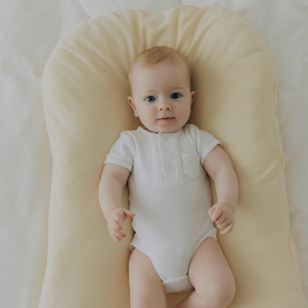 Aila + Aiden baby lounger cream travel pack photo showcases compact design