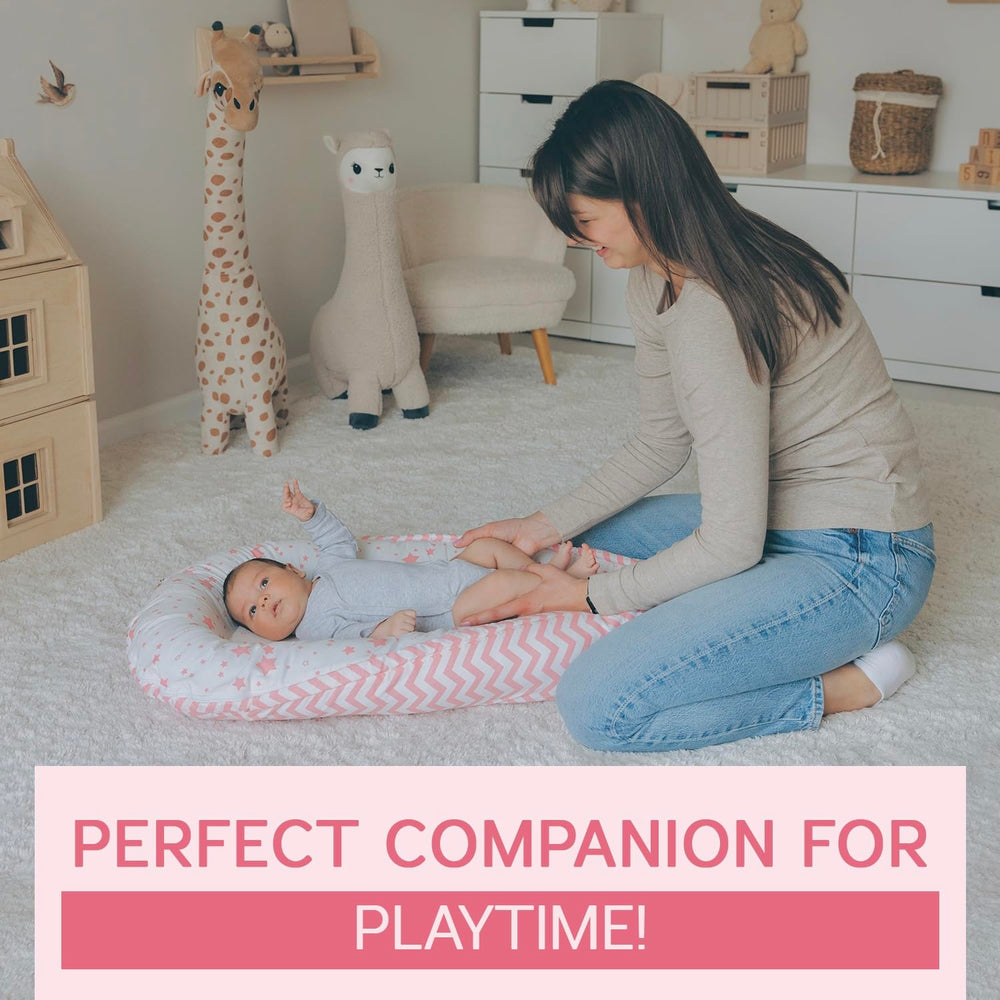 Aila+Aiden baby lounger pink in supervised use during diaper changes and bonding.