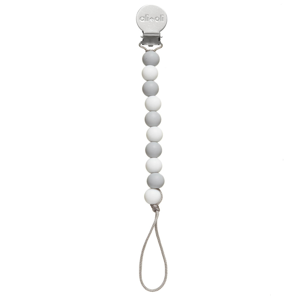 Ali+Oli pacifier clip in soft colors adds nursery organization and style.