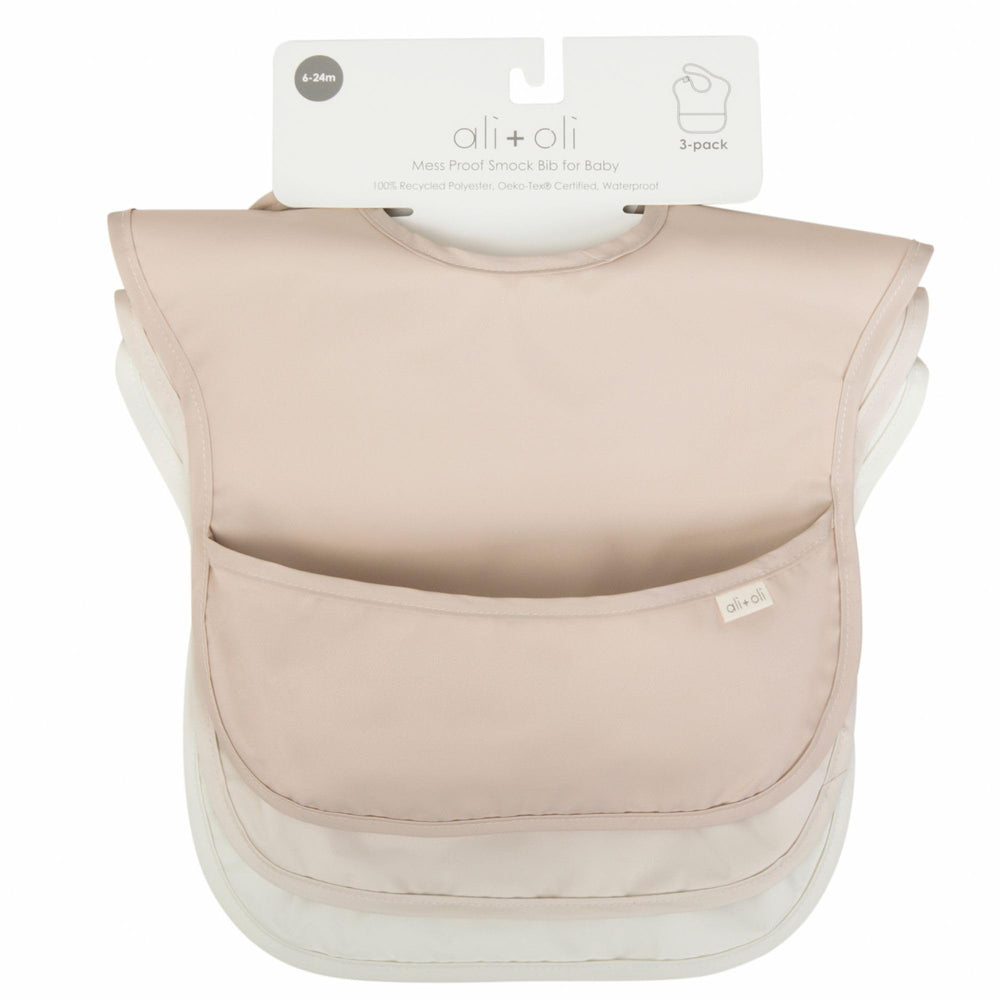 Ali+Oli Smock Bib in use during baby mealtime with a messy spread