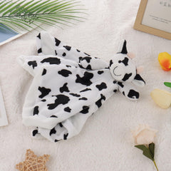 Apricot Lamb Cow Lovey in baby's hand for secure crib-time reassurance.