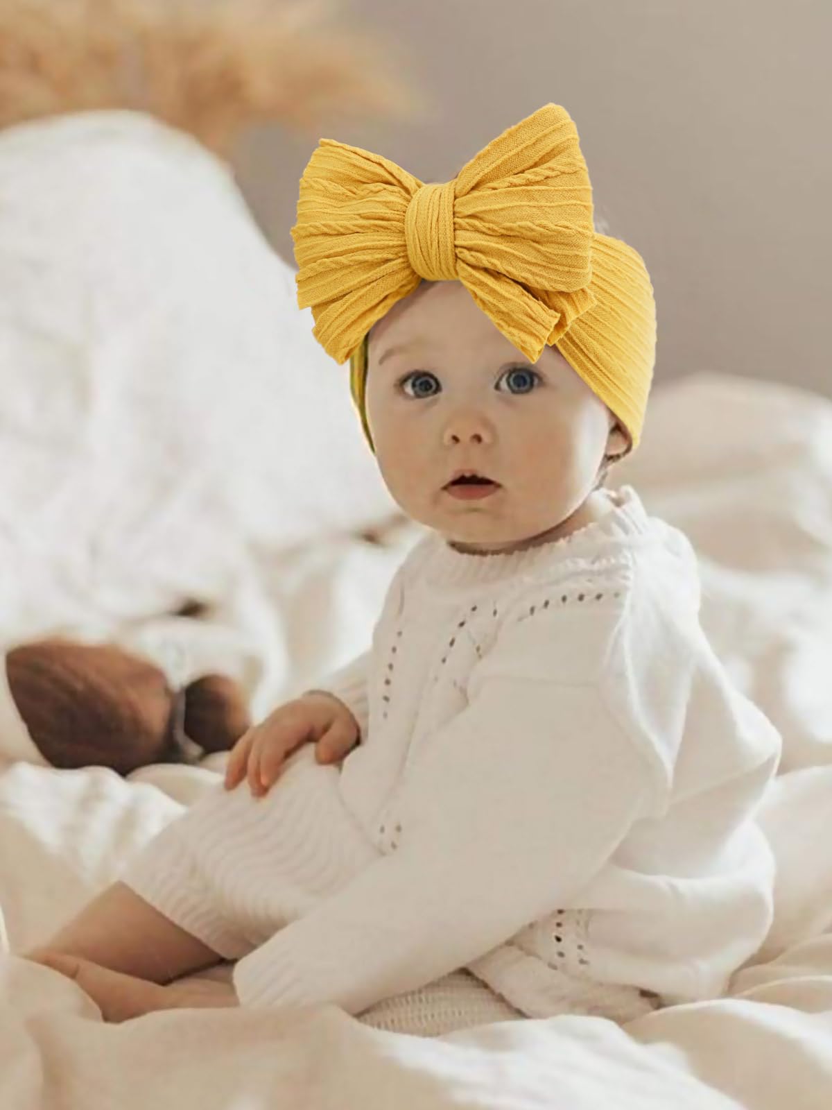 AQOKKA baby bows headbands photographed as photoshoot prop for newborns and toddlers.