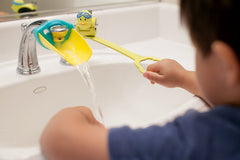 Aqueduck faucet extender in yellow shown with a sink and reach-for-water moment.