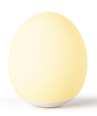 AuroraNiteBeam egg night light on table providing a soft ambient glow for baby rooms.