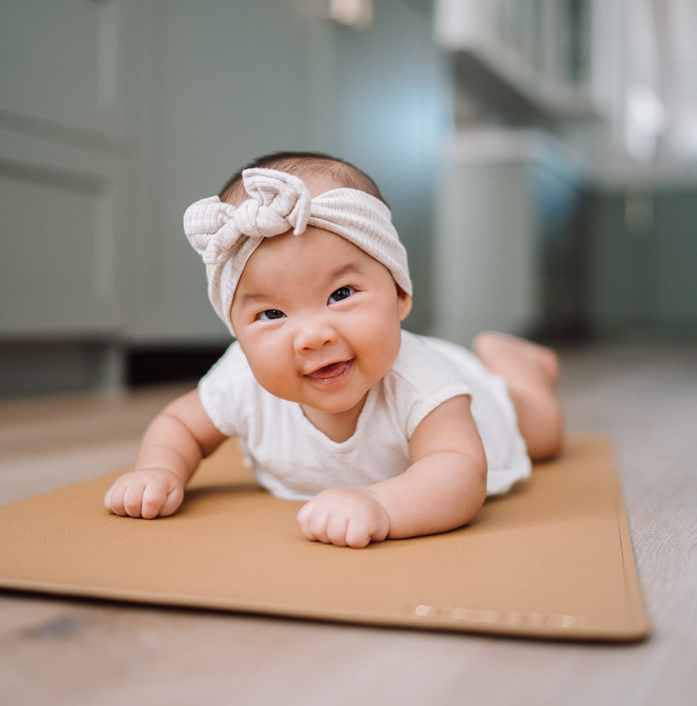 AVA + OLIVER vegan leather wipe-clean baby mat for quick cleanup after changes.