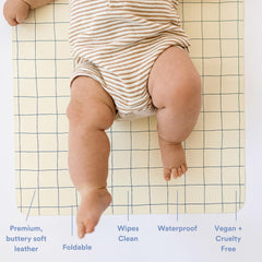 Ava + Oliver blue check changing pad in a diaper bag ready for on the go