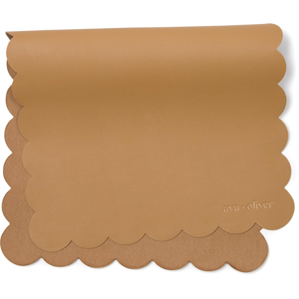 Ava + Oliver vegan leather changing mat folded in tan scallop for travel and quick diaper changes.