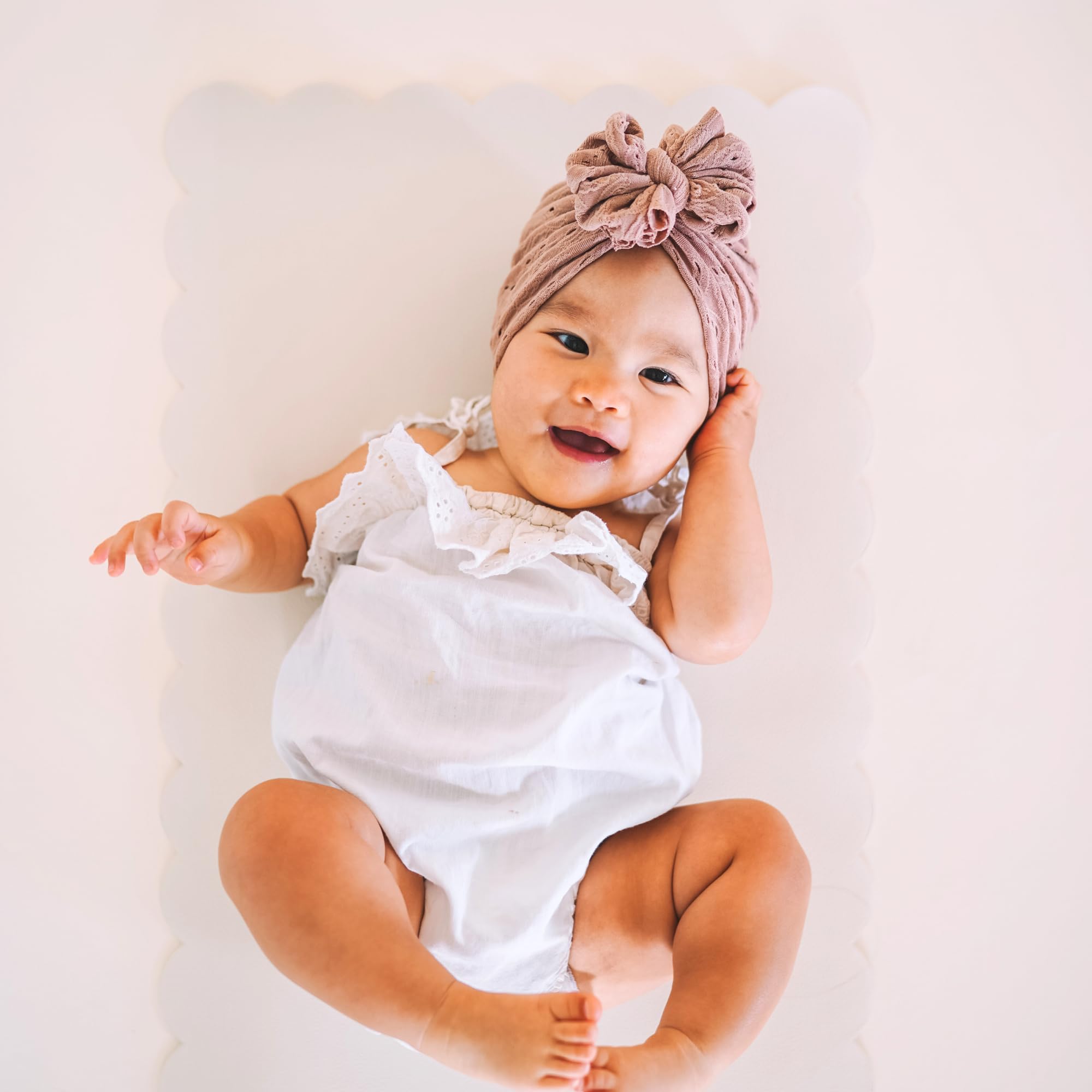 Ava + Oliver vegan leather changing mat in taupe scallop, wipe-clean surface for quick cleanup.