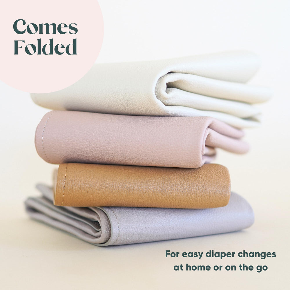 Ava + Oliver vegan leather changing mat laid flat, durable surface supports newborn to toddler diaper changes.