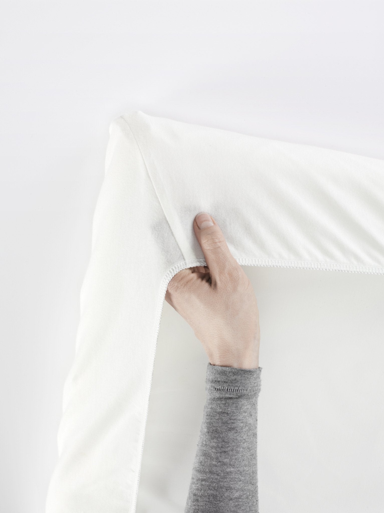 BabyBjörn Travel Crib Light sheet on mattress, showing snug fit with secure elastic.