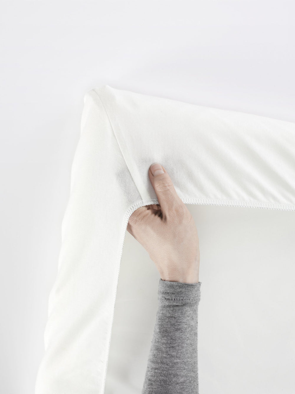 BabyBjörn Travel Crib Light sheet on mattress, showing snug fit with secure elastic.