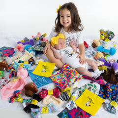 Baby Paper washability and CPSIA-tested non-toxic design shown with fabric loop for easy gifting.