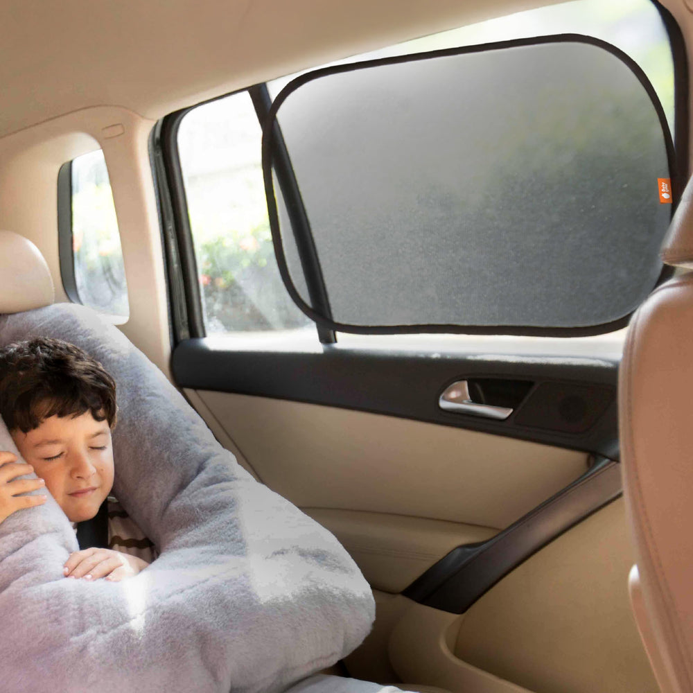 Baby Uma car window shades shown with static cling attachment on glass.