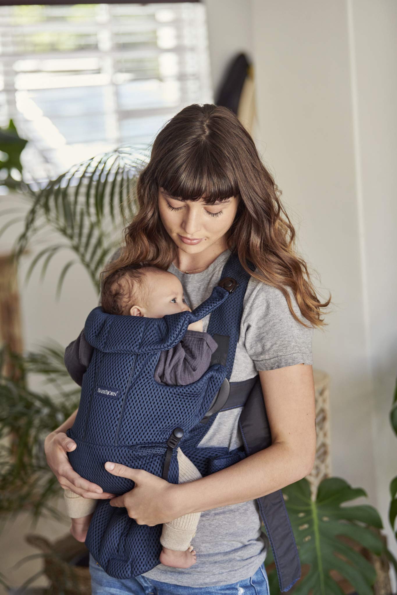 Parent wearing navy blue Carrier Free demonstrates lightweight, close contact while out.