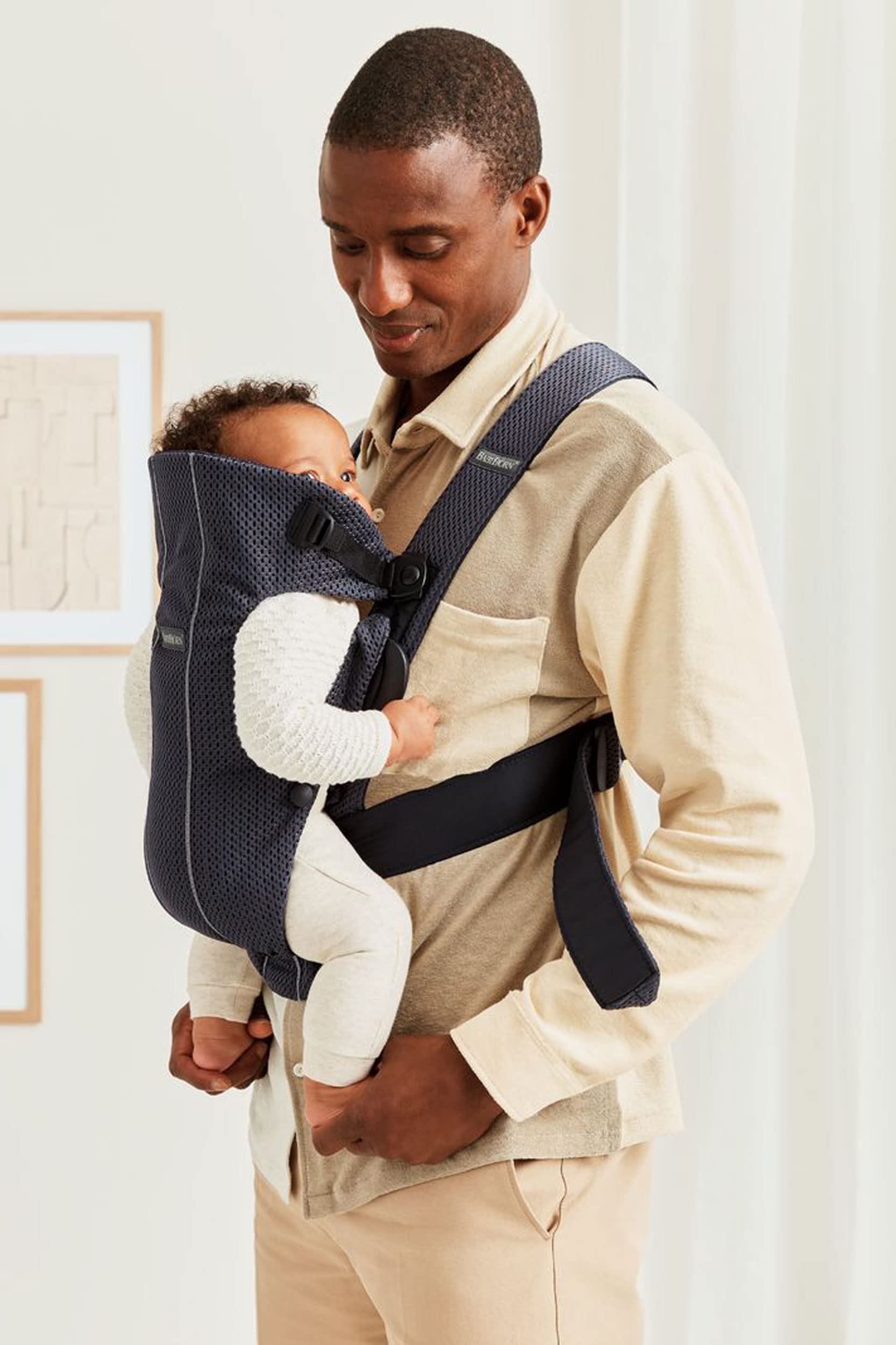 BabyBjörn Baby Carrier Mini ergonomic seat detail communicates adjustable fit as baby grows.