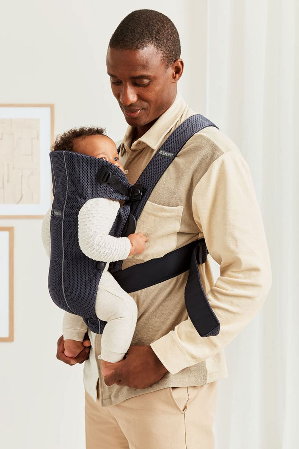 BabyBjörn Baby Carrier Mini ergonomic seat detail communicates adjustable fit as baby grows.