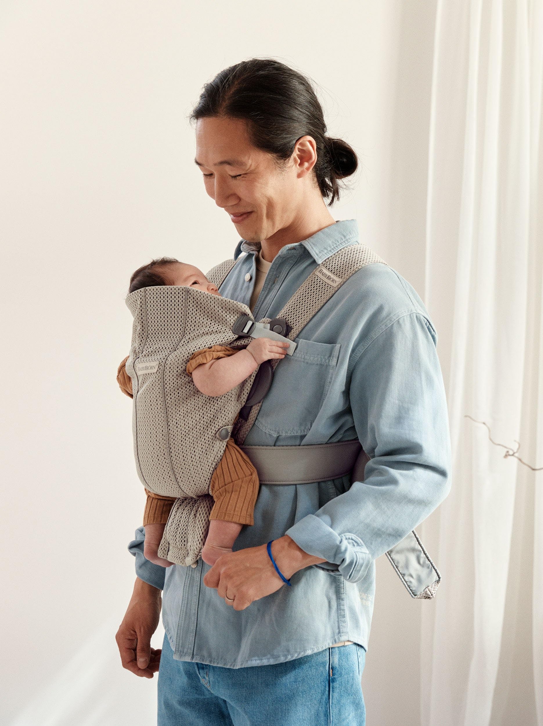BabyBjörn Mini gray-beige adjustable seat demonstrates growth with baby