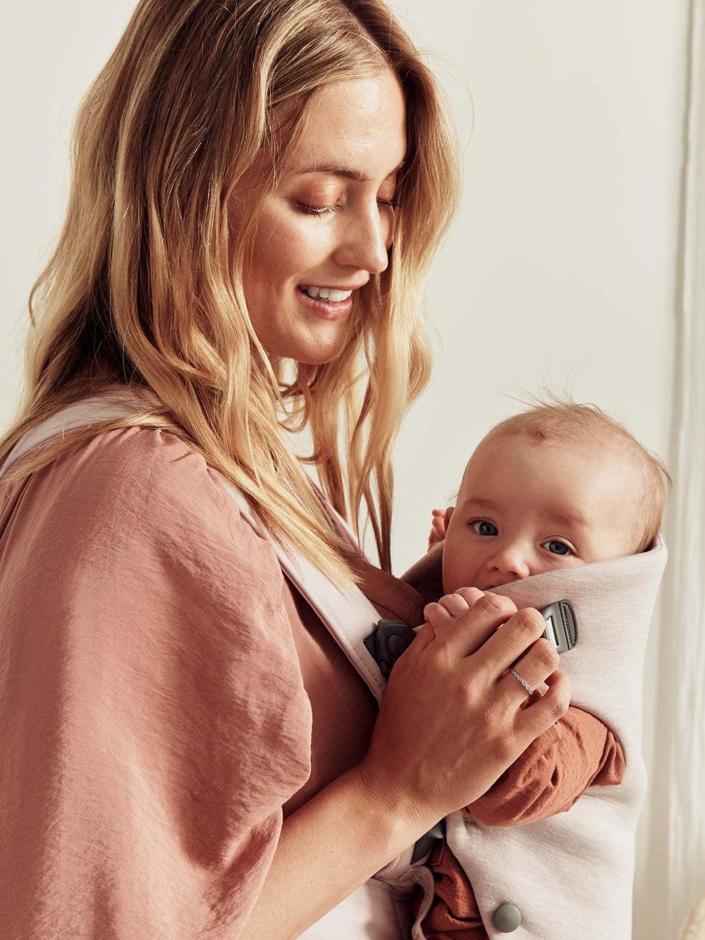 BabyBjörn Baby Carrier Mini open-front section demonstrates quick access to lift a sleeping baby.