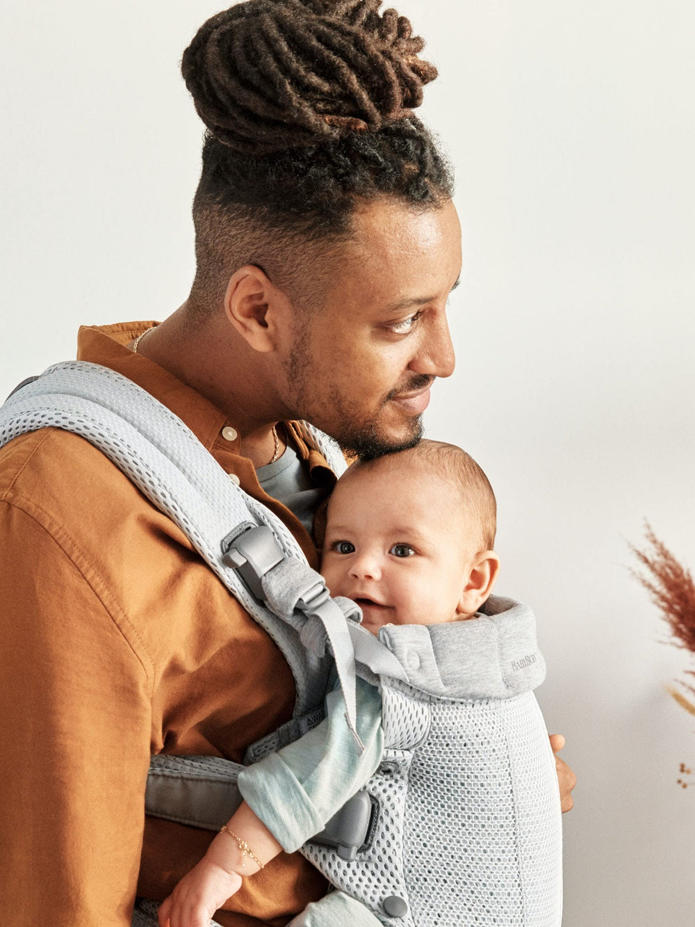BabyBjörn Harmony back-carry position shows hands-free versatility for caregivers.