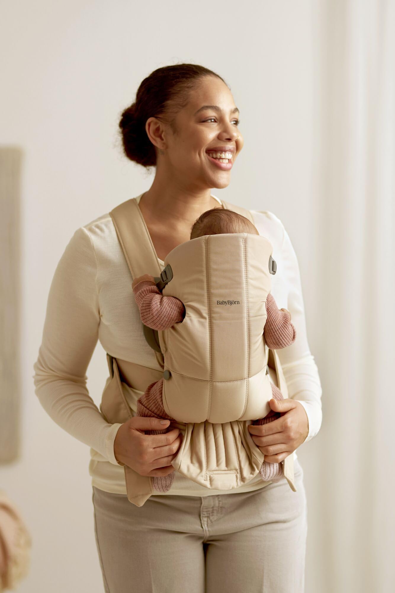 BabyBjörn Baby Carrier Mini satin-woven cotton close-up suggests luxe comfort.
