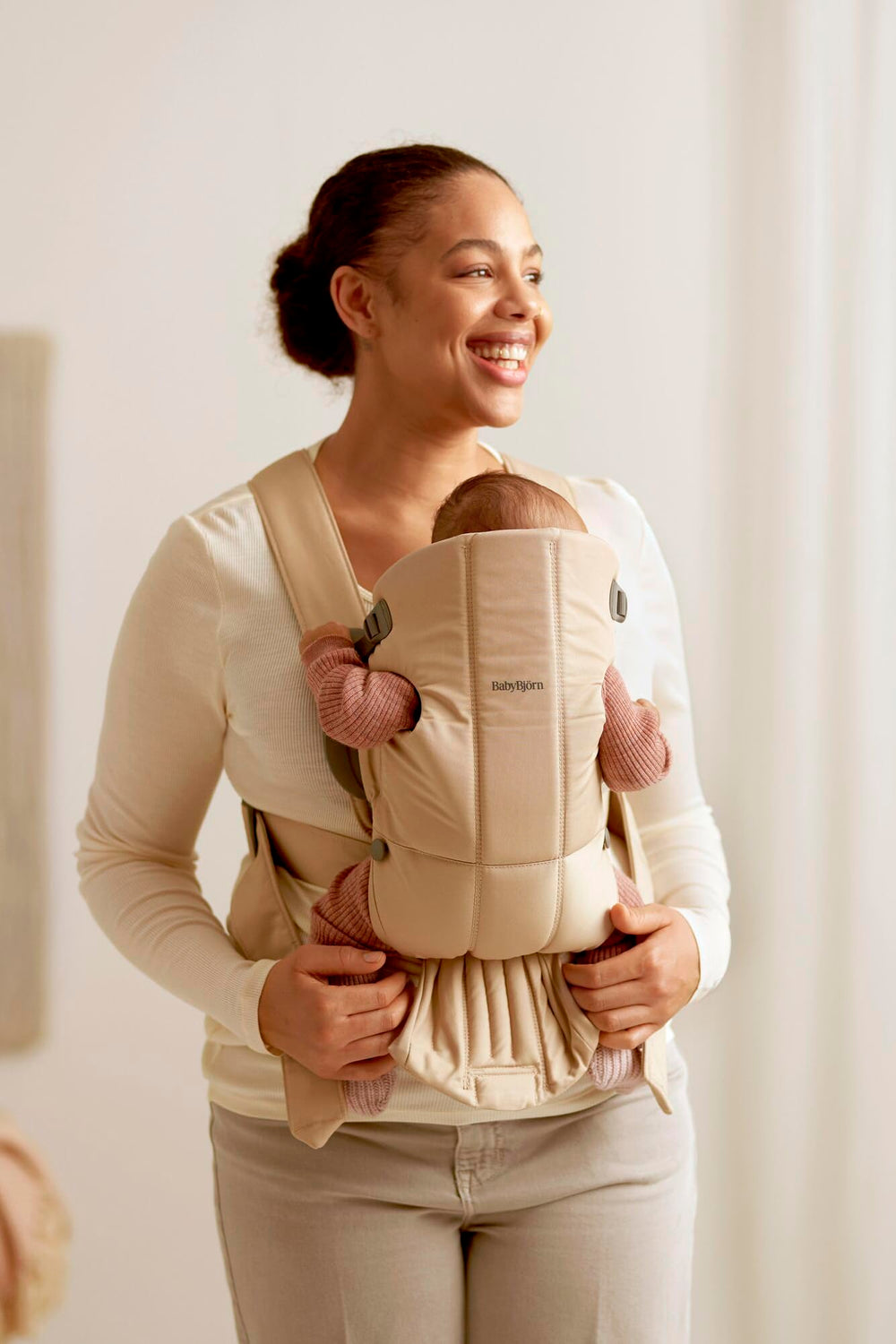 BabyBjörn Baby Carrier Mini satin-woven cotton close-up suggests luxe comfort.