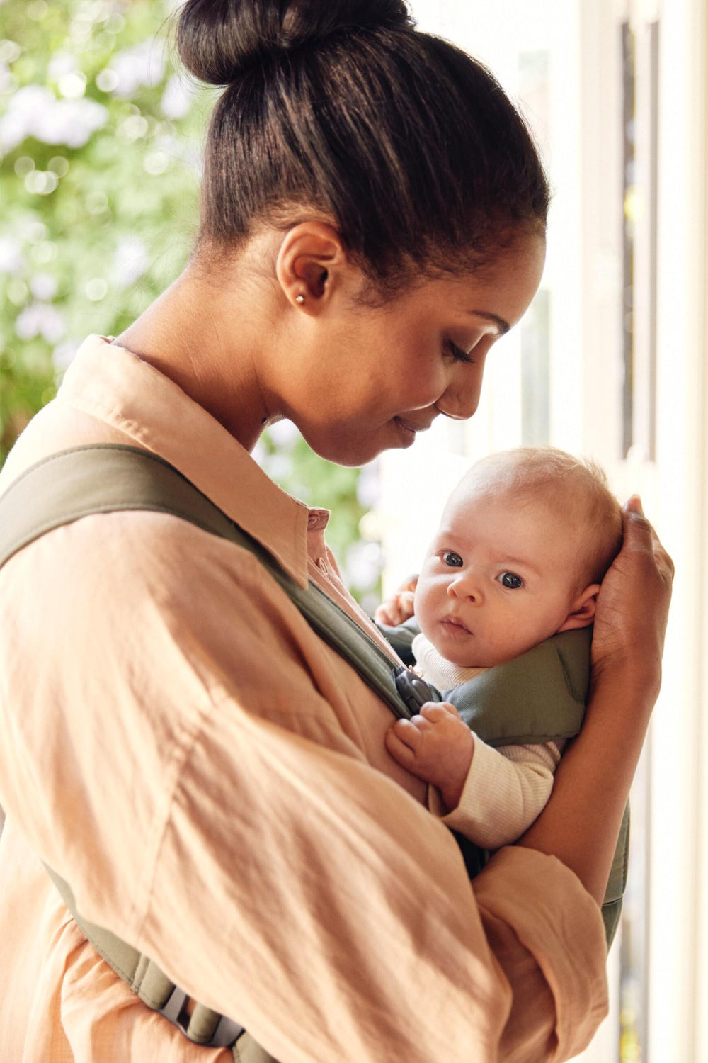 BabyBjörn Mini woven dark green front carry option for secure newborn carry.