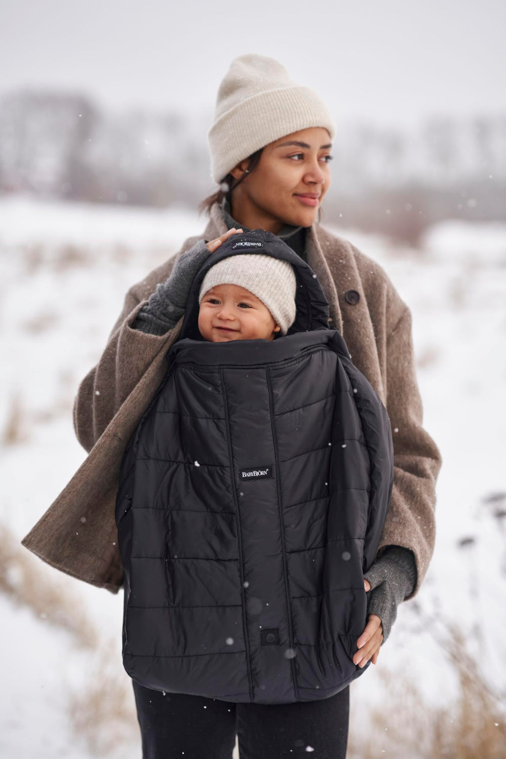 BabyBjörn Winter Cover in sleek black complements any carrier while keeping warmth intact.