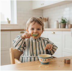 Babyflip long sleeve bib waterproof-demo demonstrates spill-proof protection during feeding.