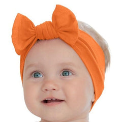 BABYGIZ headband orange-bow close-up showing soft cotton stretch for gentle wear.