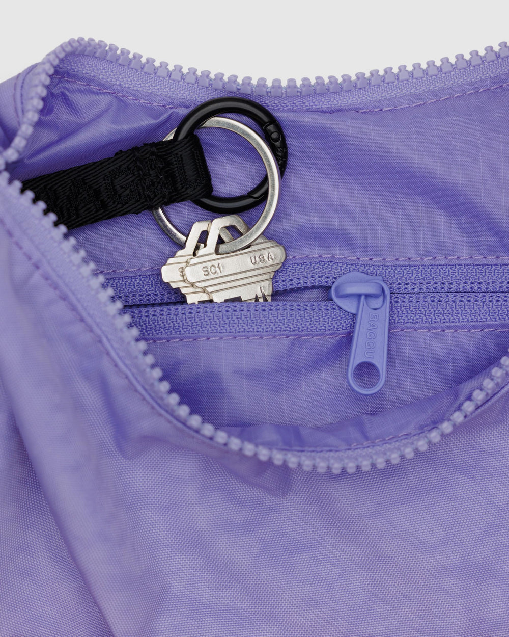 BAGGU Small Nylon Crescent Bag in Wisteria, interior view highlighting interior zip pocket and key leash.