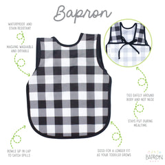 BapronBaby white buffalo plaid bapron worn by child for full-coverage protection during meals.