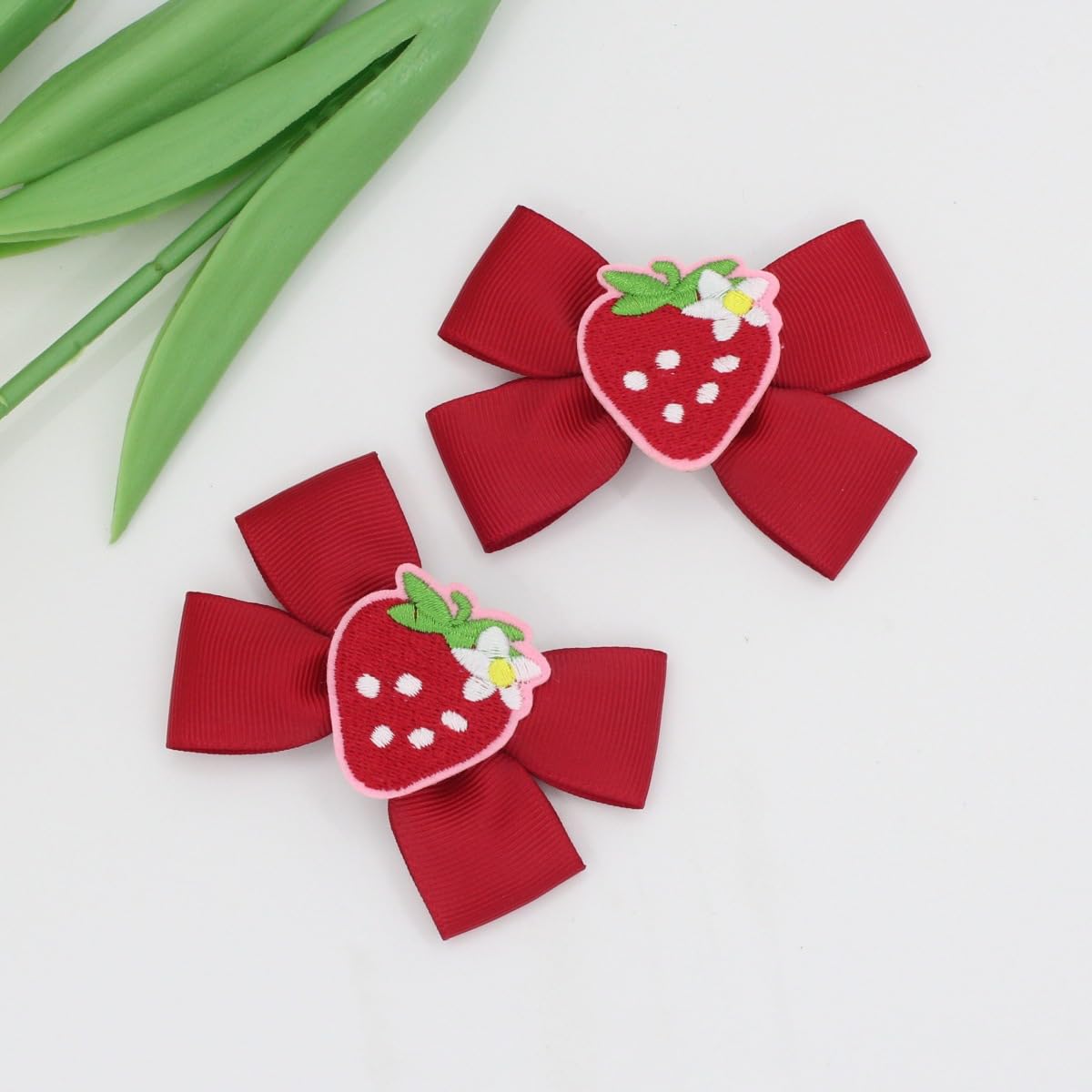 Close-up of BBTDIN strawberry clip showing secure snap for daily wear.