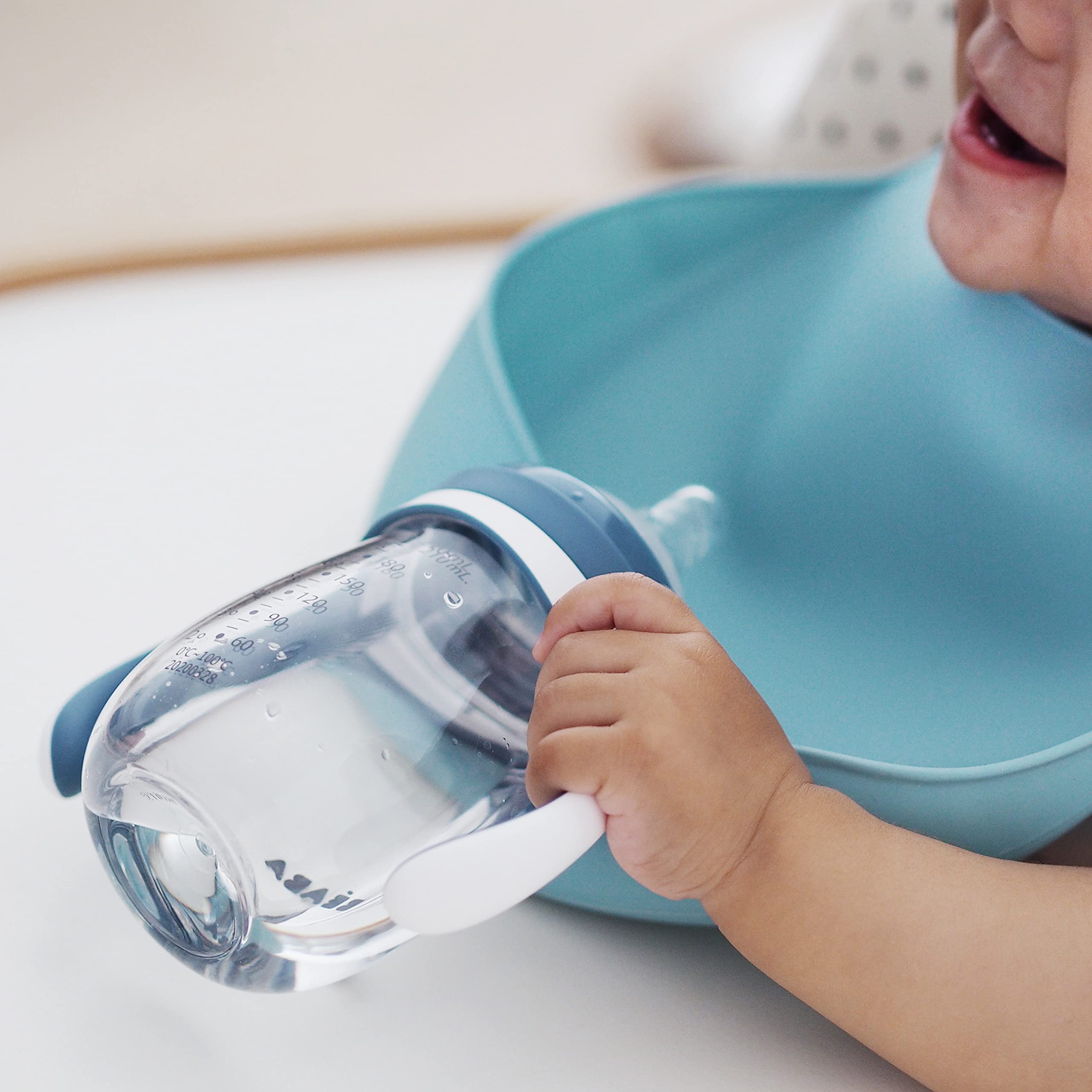 BEABA Rain baby holding the sippy cup ready to sip during daily meals