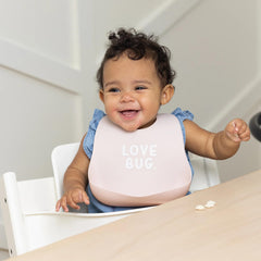 Bella Tunno deep-pocket silicone bib catching crumbs during self-feeding and messy bites.