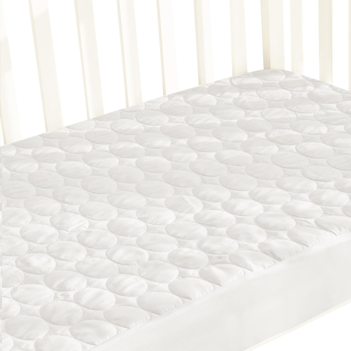 Biloban crib mattress protector on a standard mattress provides waterproof protection and a smooth sleeping surface.