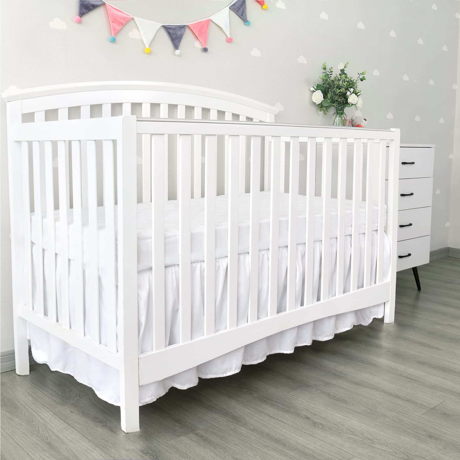 Biloban easy-on-off crib skirt with elastic straps for quick setup.