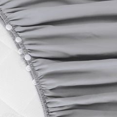 Biloban crib skirt grey side view highlights wrap-around design for secure fit