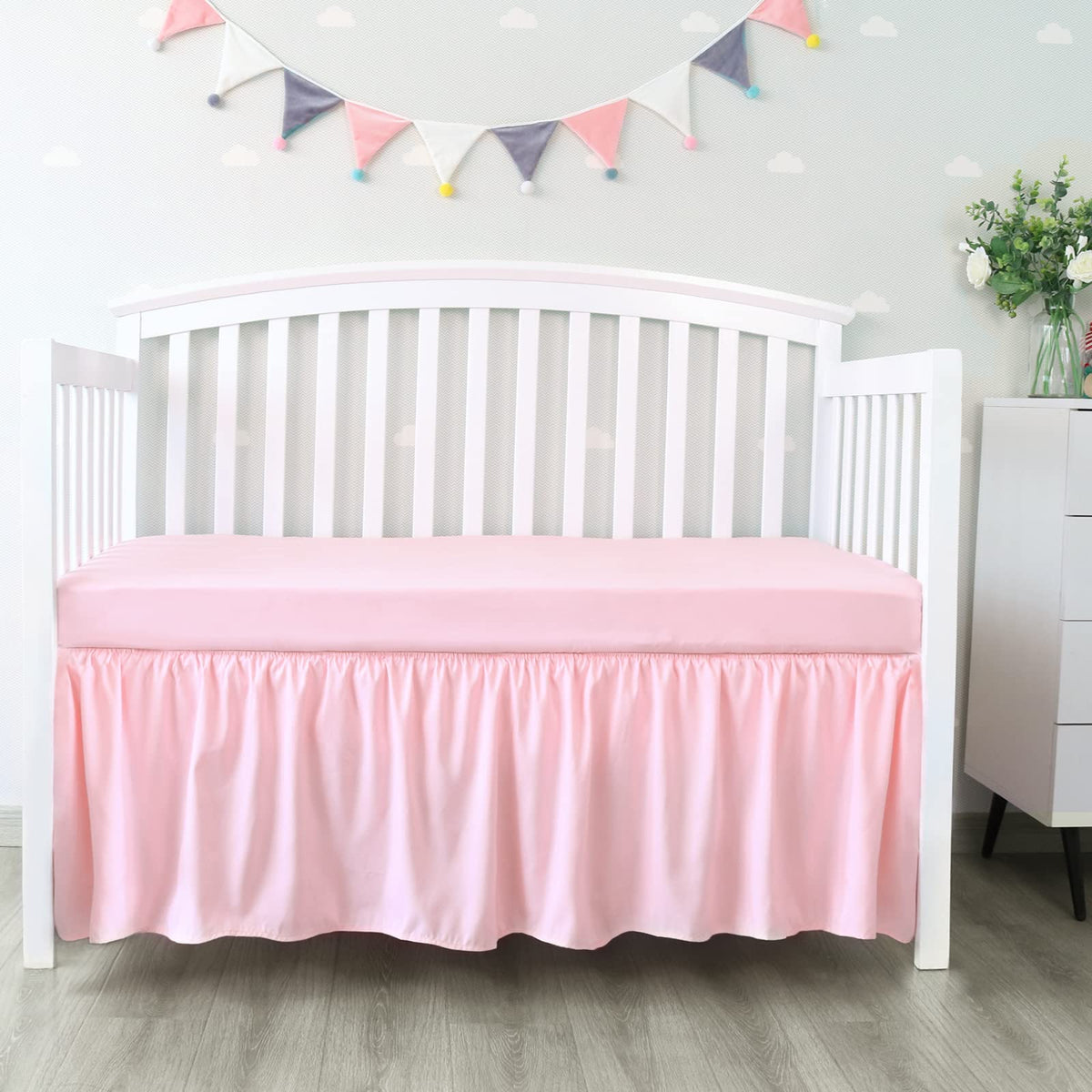 Biloban crib skirt pink pleated front view shows tidy under-crib space coverage