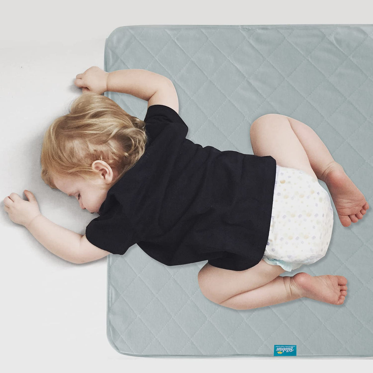 Biloban waterproof crib mattress protector in gray covers spills and accidents.