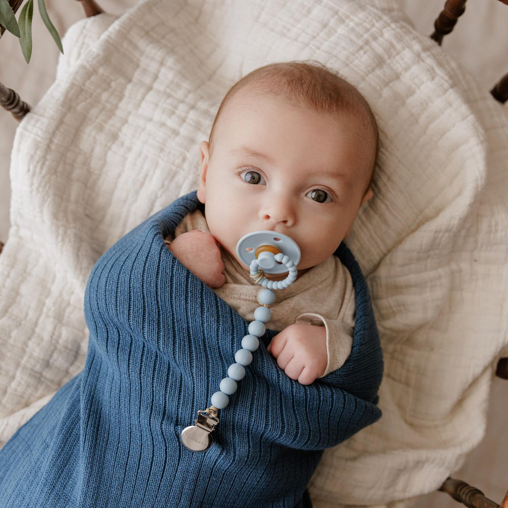 Infant using Bleu La La Luladream pacifier during stroller time for soothing moments.