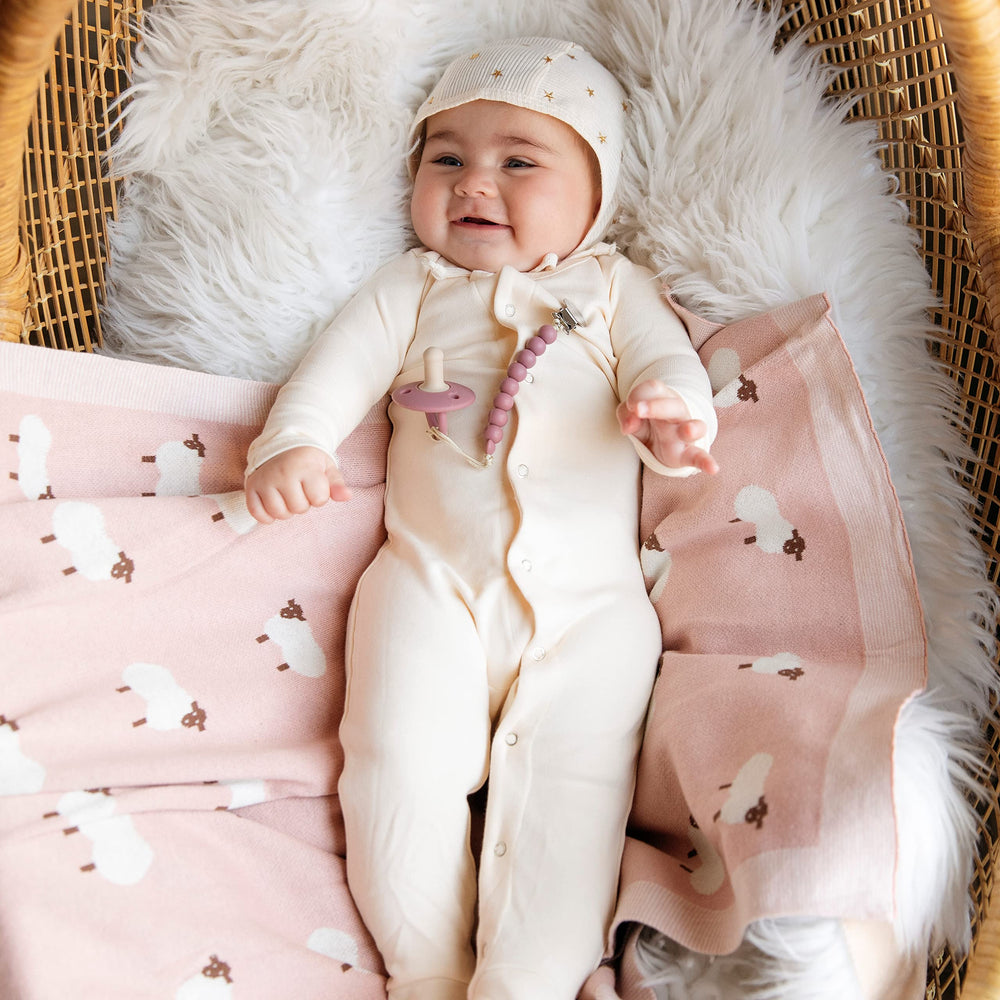 Bleu La La swaddle blanket in nursery illustrates gentle wrapping for better sleep.
