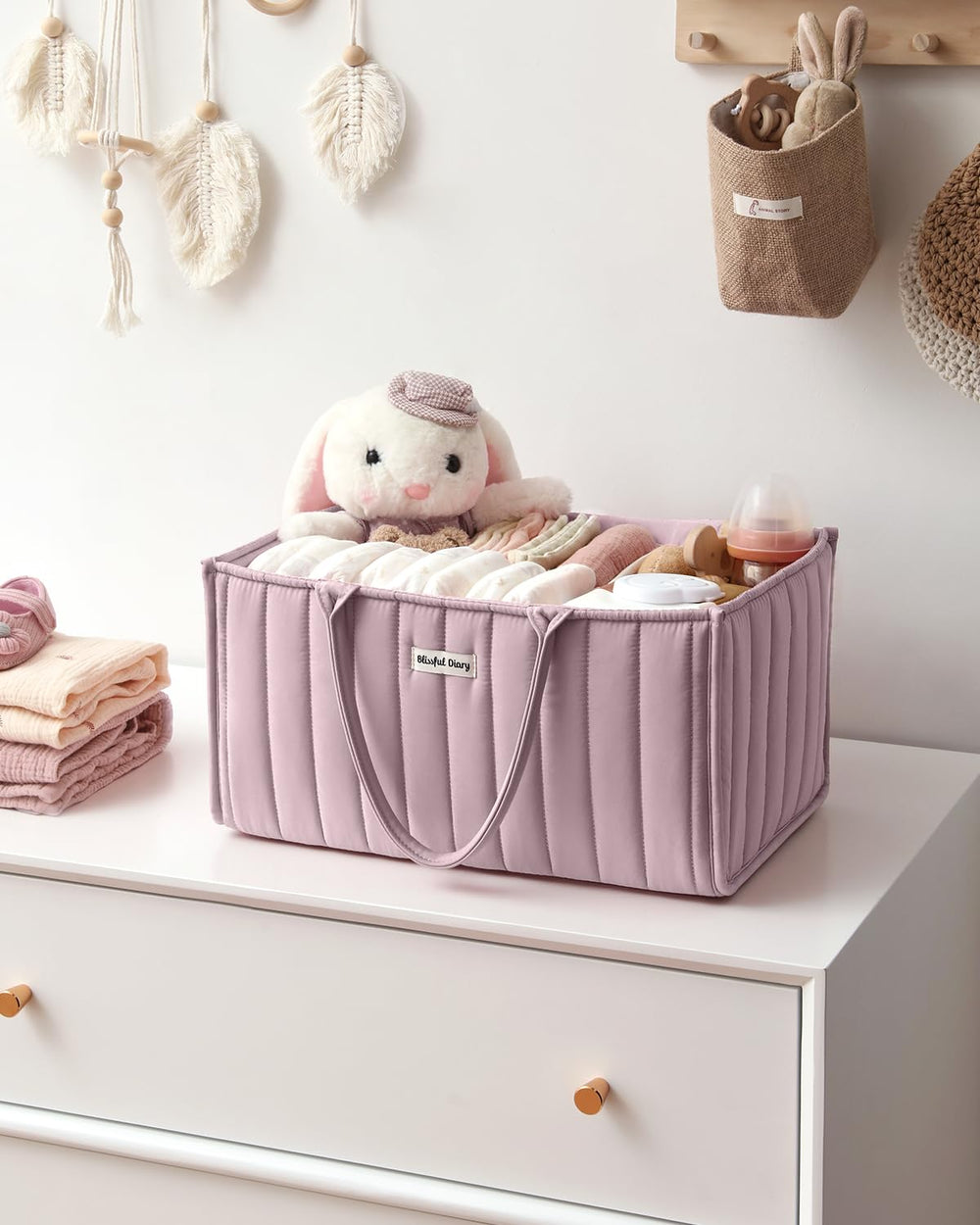 Blissful Diary mauve caddy complements changing station with modern aesthetics.