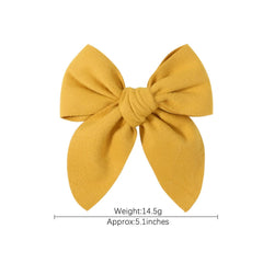 BOENBE LOVED linen-texture yellow bow clip close-up highlighting soft fabric.
