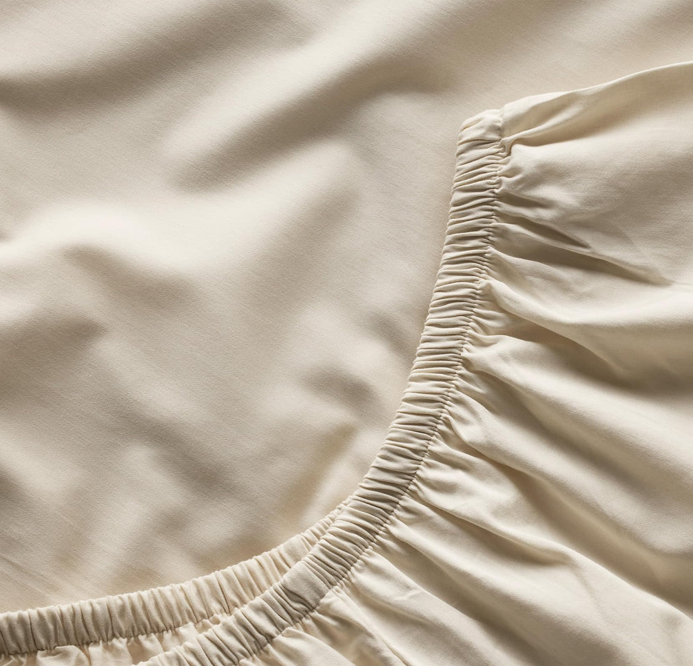 Boll & Branch Signature crib sheet secure-fit elastic band demonstrating snug mattress coverage.