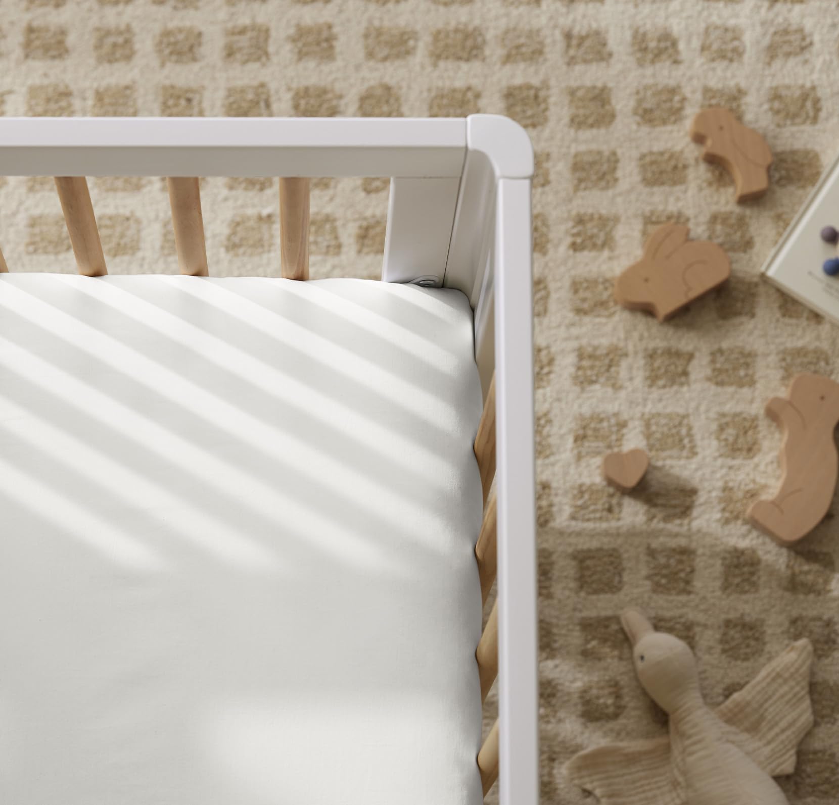 Boll & Branch Signature crib sheet on standard crib mattress illustrates precise fit and durability.