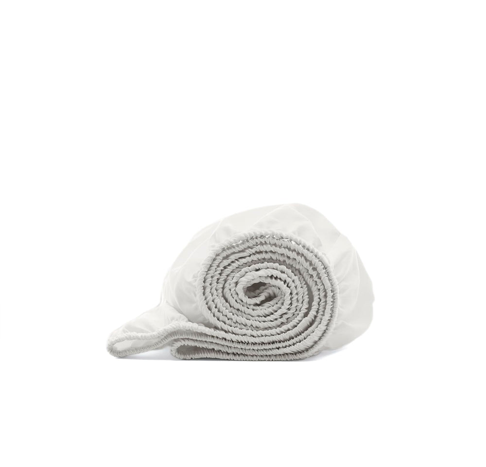 Boll & Branch Signature crib sheet white close-up shows softness for baby sleep.